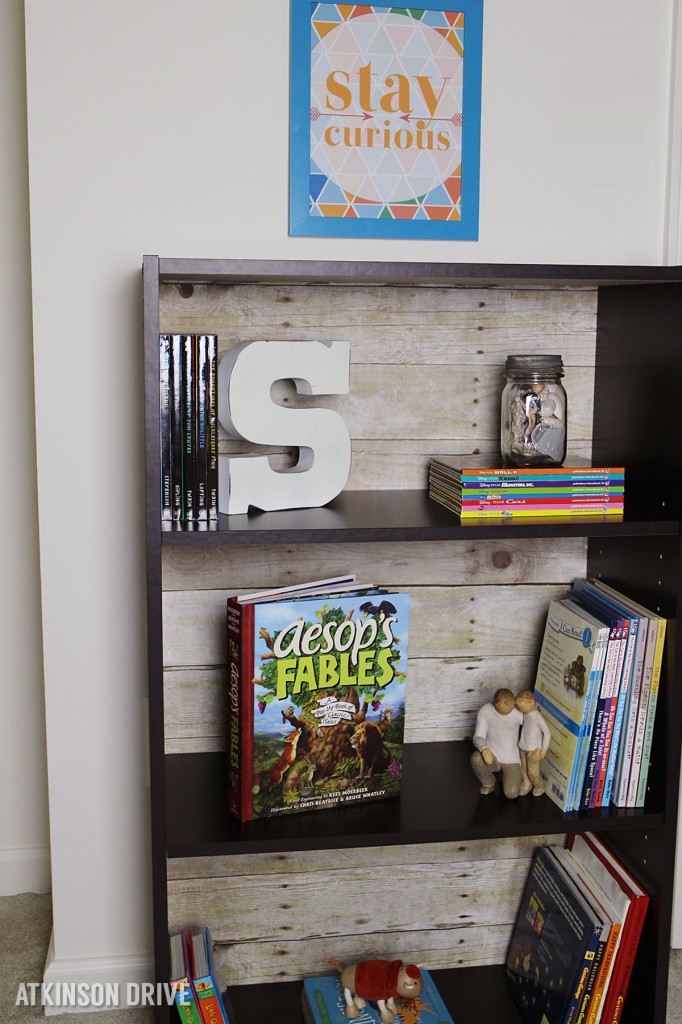 Create a faux wood-backed bookcase with a few simple tools, 5 minutes of your time, and only $10! /// by Atkinson Drive